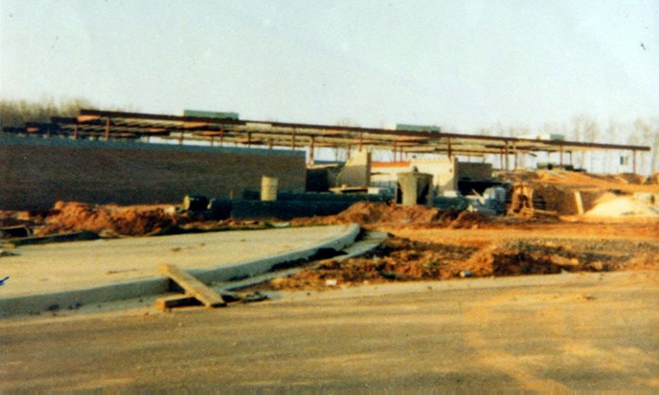 Color photograph of Laurel Ridge Elementary School during construction. Some cinderblock walls and steel framing are in place. Construction supplies and equipment are spread throughout the site.
