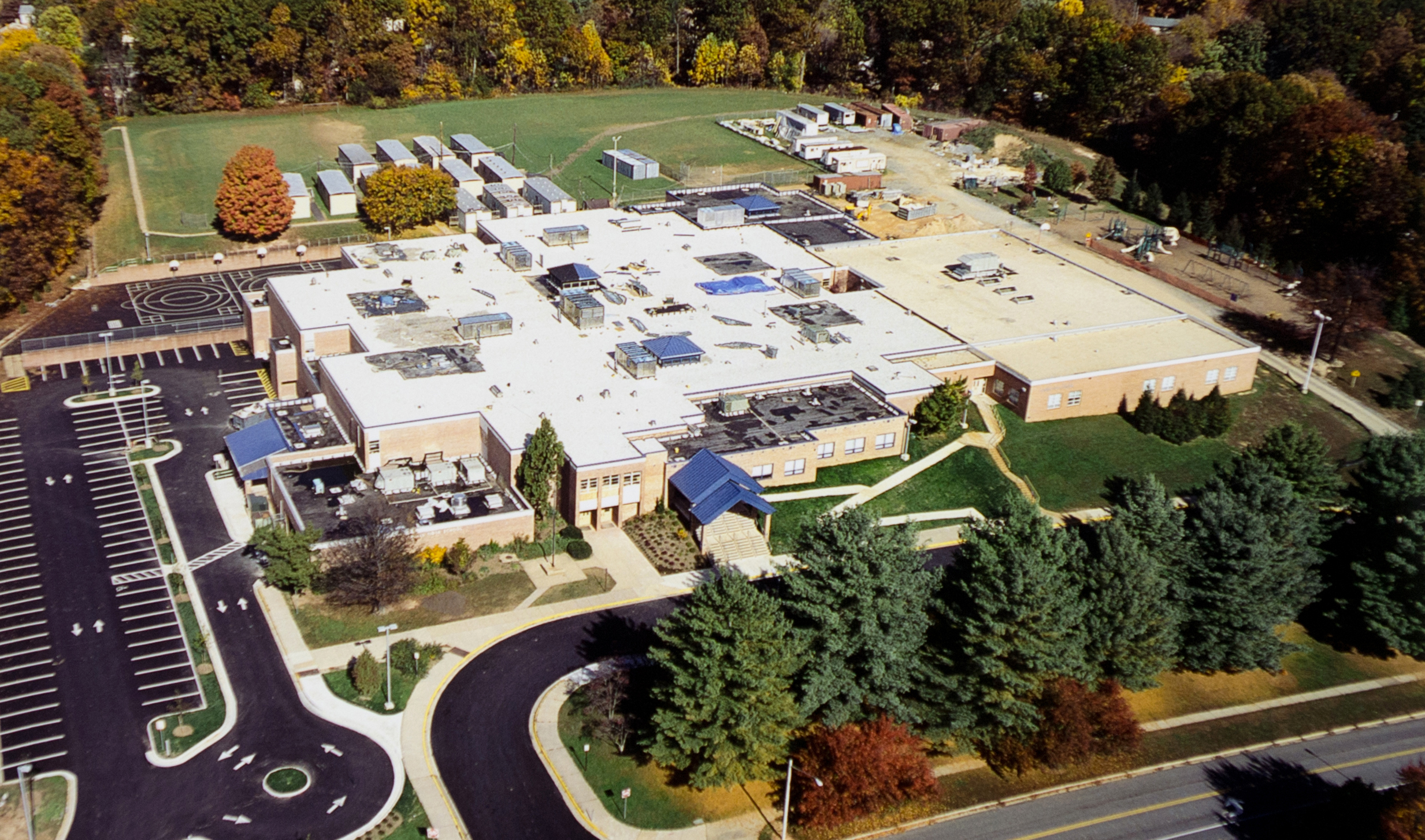 Aerial photograph of Laurel Ridge Elementary School, taken in October 2004. The photograph, taken from the front of the building, shows thirteen mobile classrooms situated behind the school on the playing field. Construction equipment is visible on the far right rear of the building where work is still underway. 