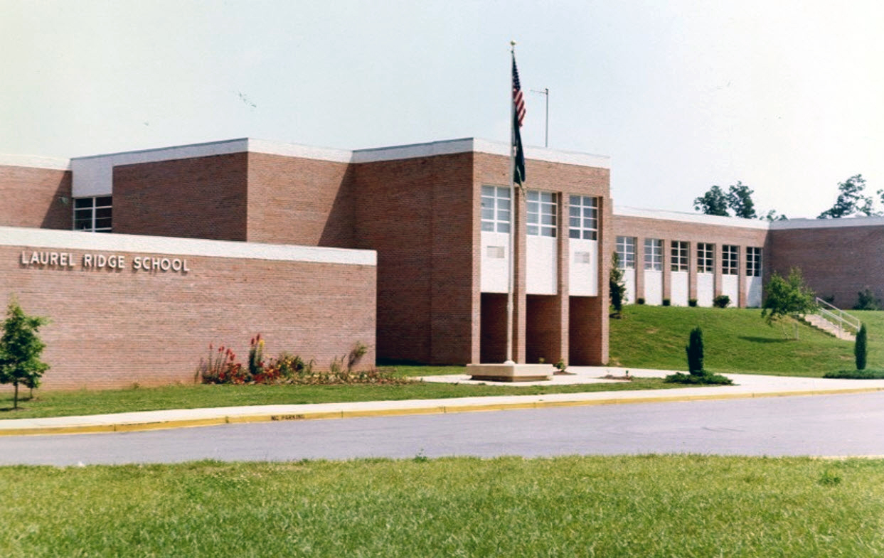 Color photograph of the main entrance of Laurel Ridge Elementary School taken in the early-to-mid 1970s. The shrubs and trees planted in front of the building have grown.